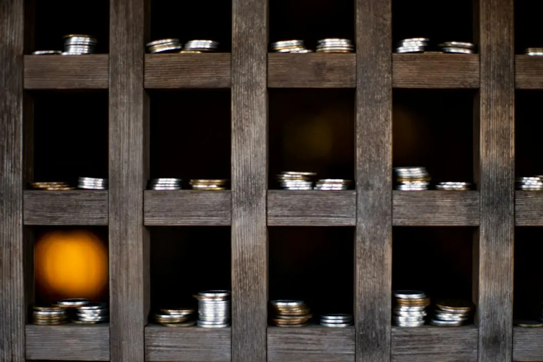 Stacks of coins in a dark wooden rack, for working out the monthly price of Lux IPTV plans